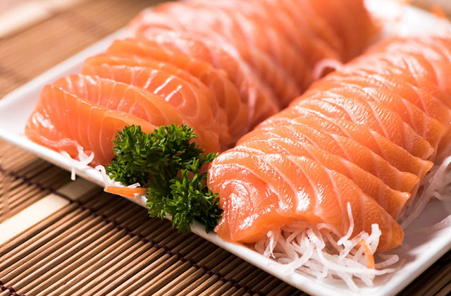 Bandeja com fatias de salmão, cortado para sashimi